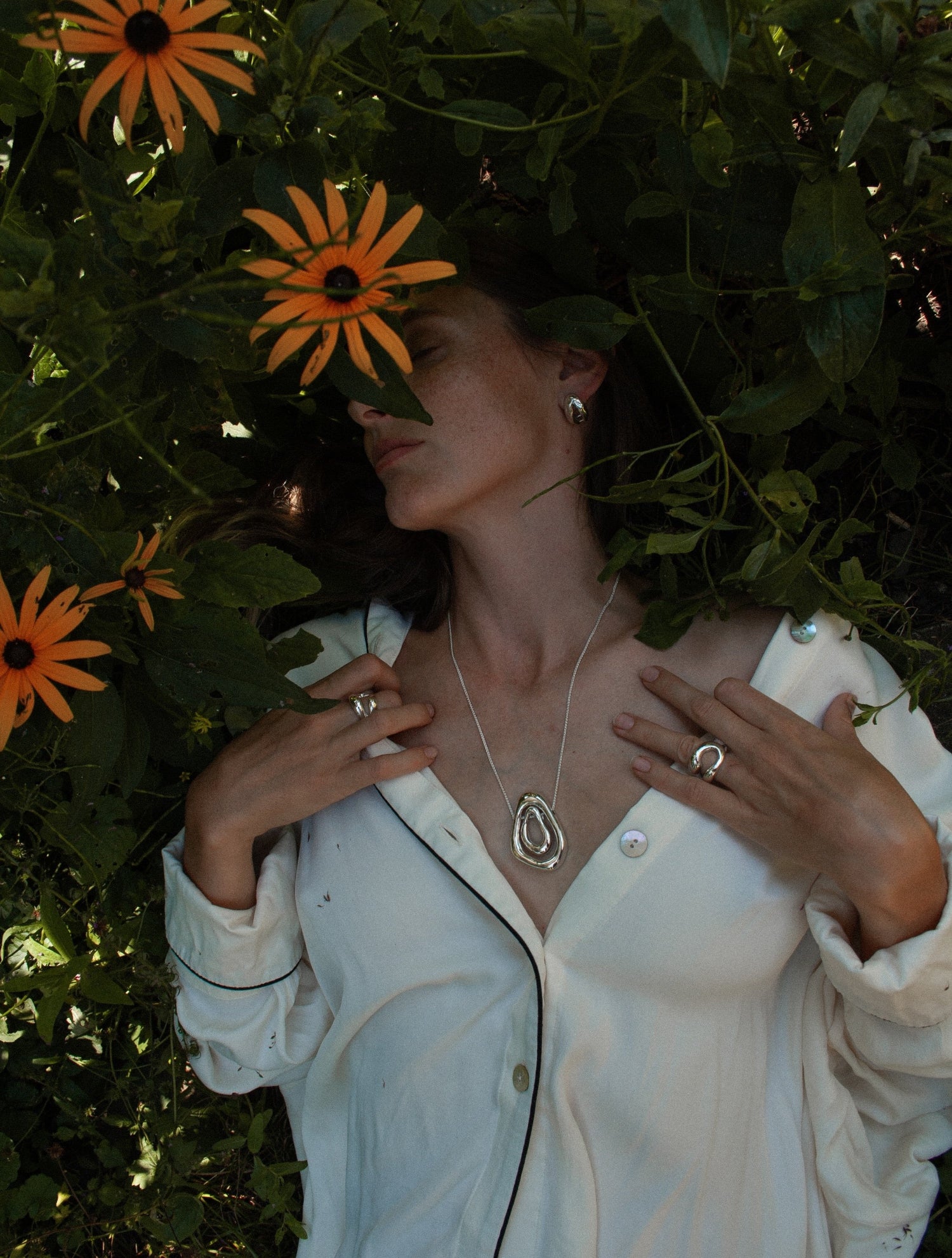 The Andrea Pendant worn by a model, demonstrating its adaptability and elegance. The pendant's geometric lines and polished finish complement various outfits, adding a touch of modern sophistication.