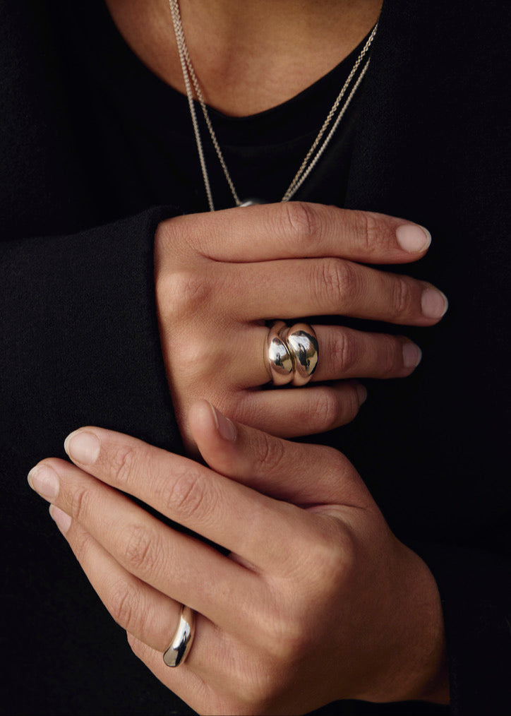 Close-up of a model's finger wearing the Anna Ring together with the twin rings, emphasising its unique wavy form and comfortable fit.