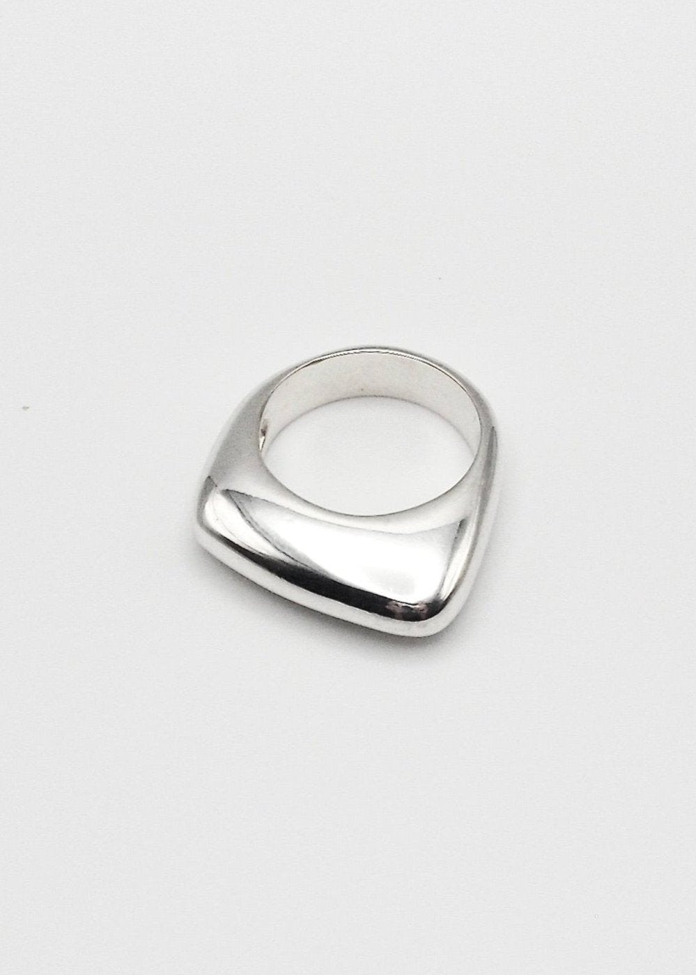 Dagmar Ring displayed on a neutral background, highlighting its bold design and mirror-polished sterling silver finish.