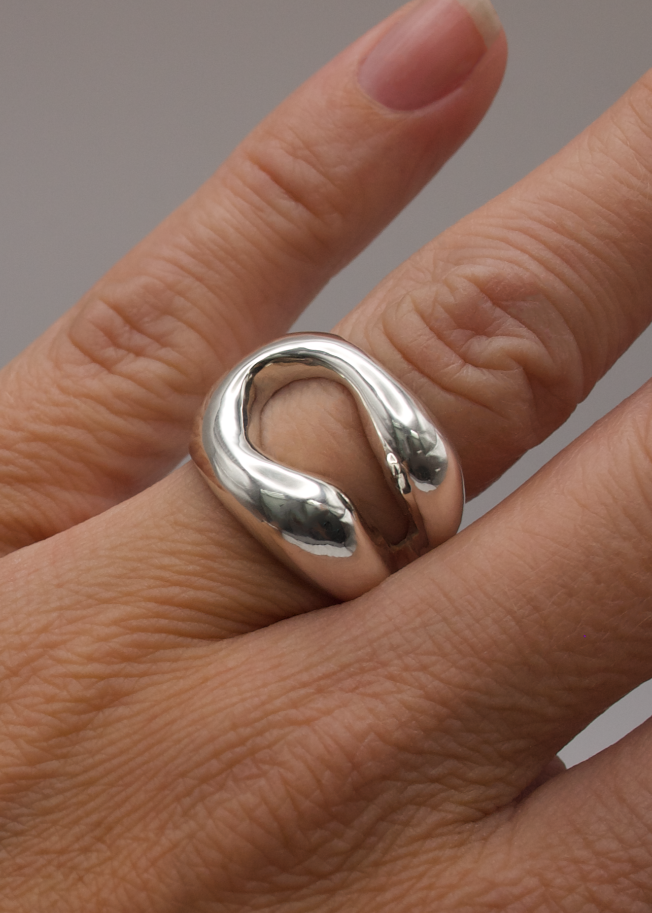 Eliza_ring_Seola_Atelier_925_sterling_silver_statement_ring_organic_ring, ring on finger. Detailed view of the Eliza Ring, focusing on its intricate design and the interplay of negative space within its organic form.