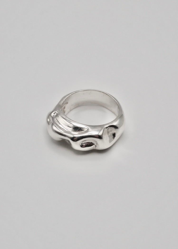 Esther Ring displayed on a neutral background, highlighting its textured design and mirror-polished sterling silver finish.
