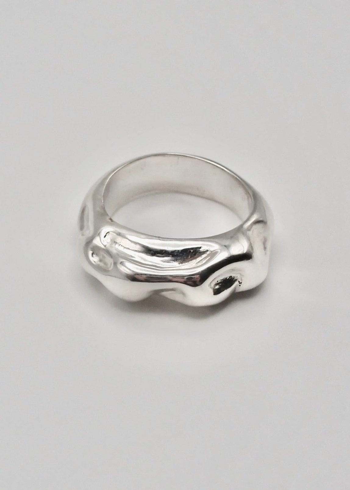 Esther Ring displayed on a neutral background, highlighting its textured design and mirror-polished sterling silver finish.