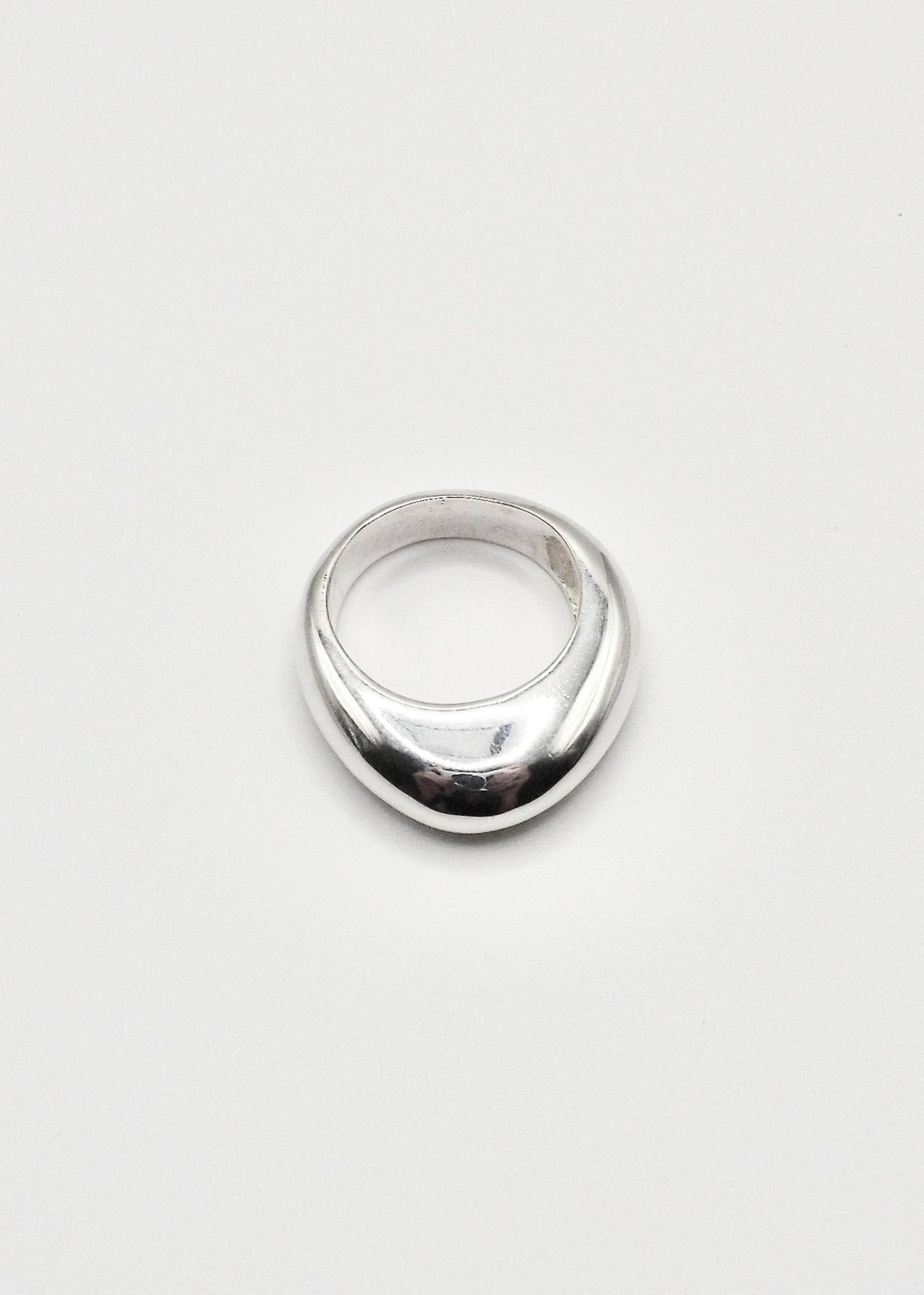 Astrid Ring displayed on a neutral background, highlighting its sleek design and mirror-polished sterling silver finish.