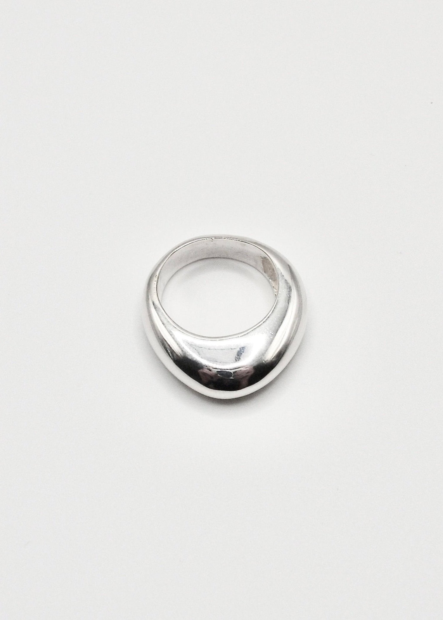 Astrid Ring displayed on a neutral background, highlighting its sleek design and mirror-polished sterling silver finish.