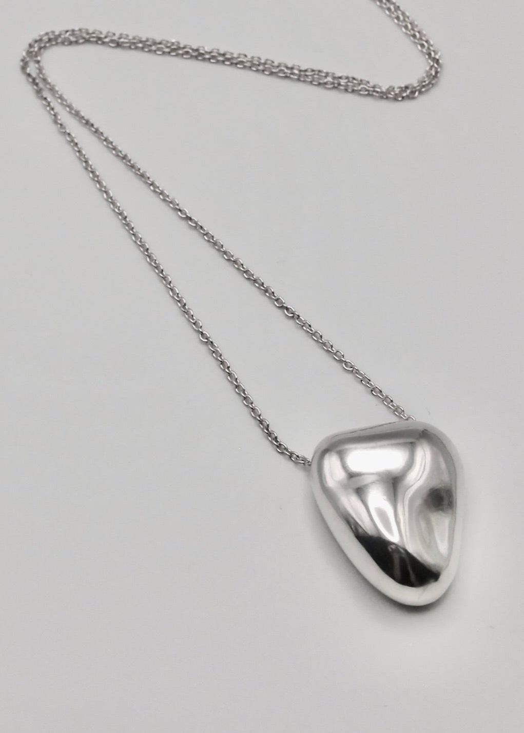 Heart Pendant displayed on a neutral background, highlighting its organic shape and mirror-polished sterling silver finish.