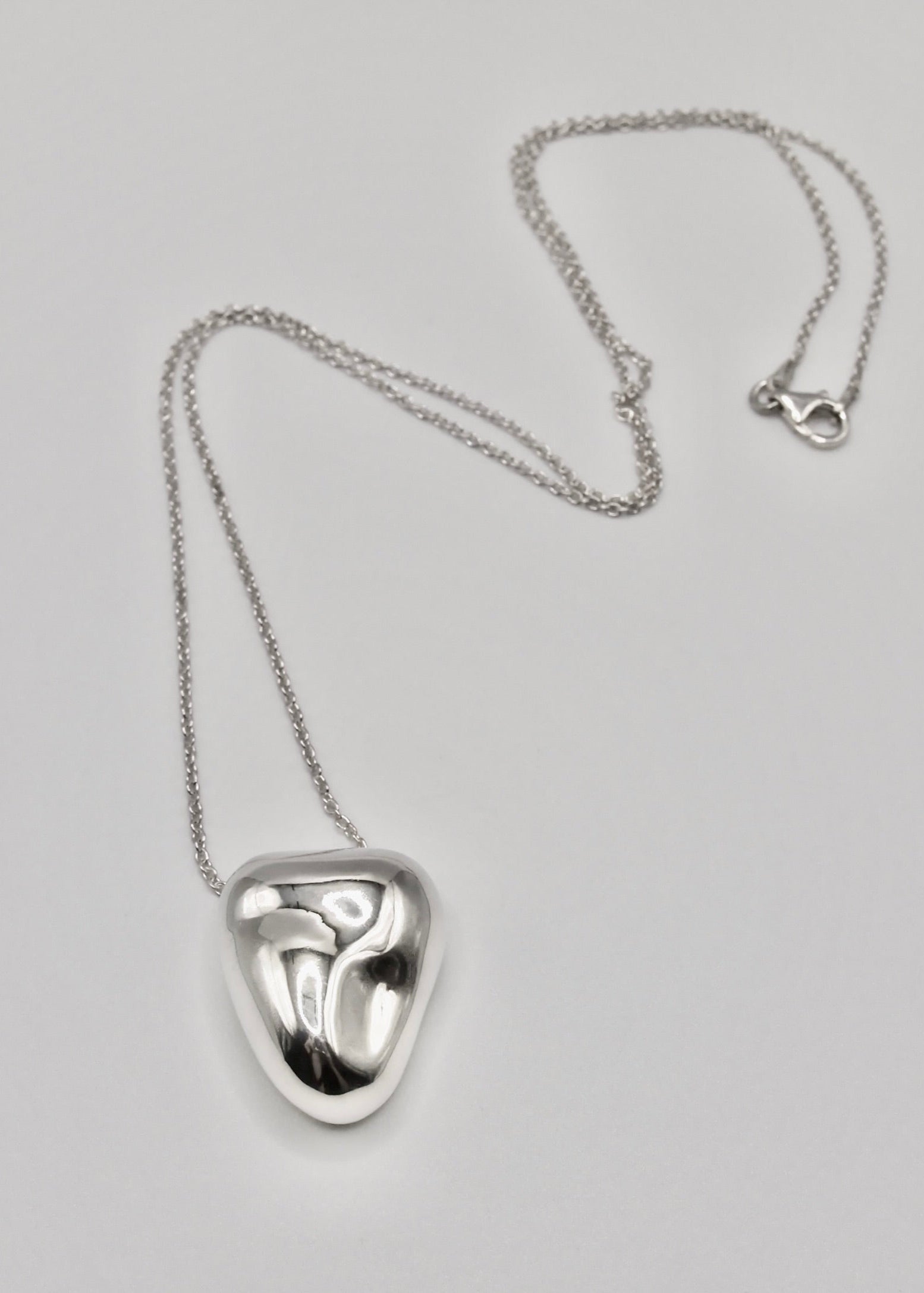 Heart Pendant displayed on a neutral background, highlighting its organic shape and mirror-polished sterling silver finish.Tiffany chain that comes in two lengths.