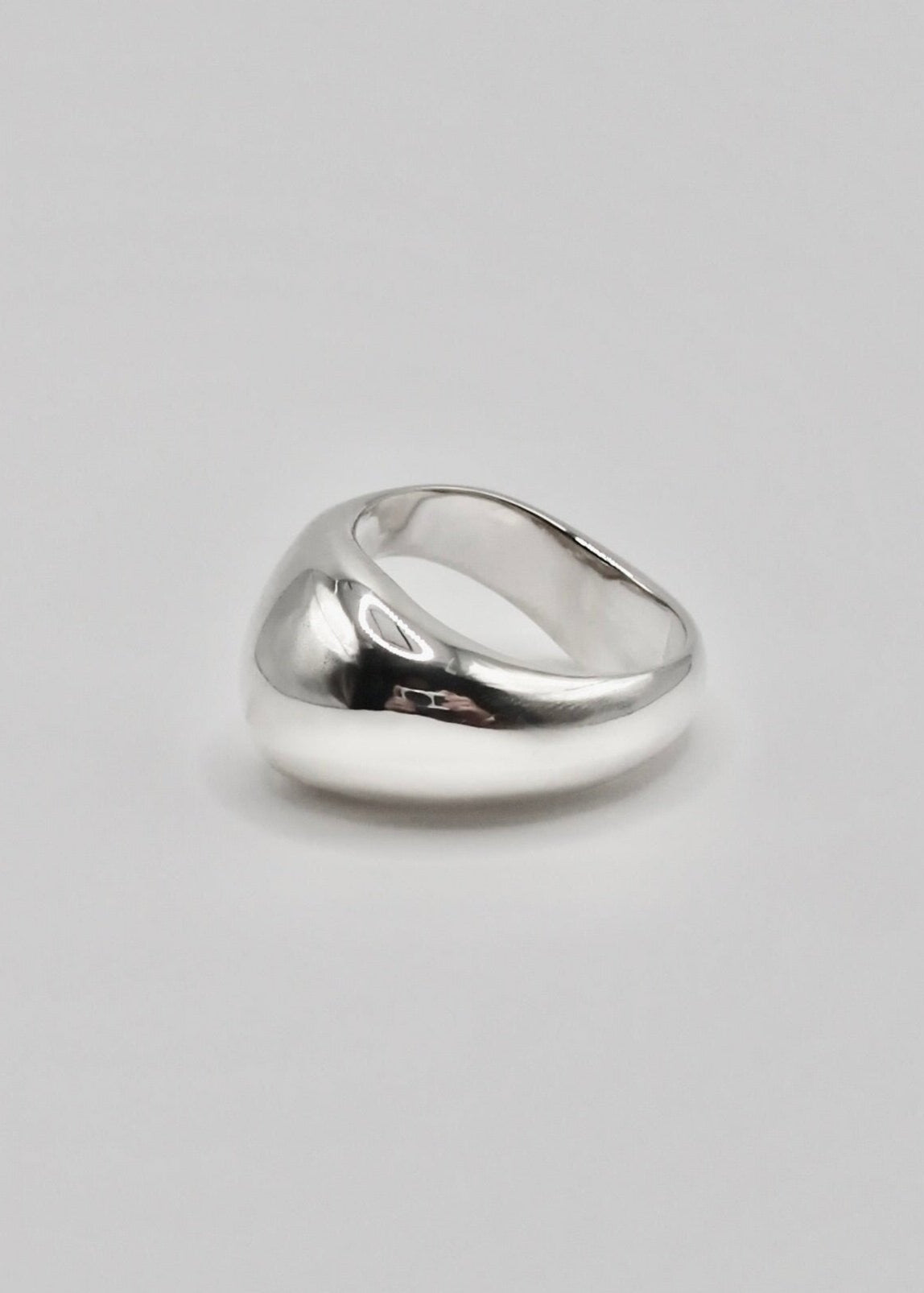 Ingrid Ring displayed on a neutral background, highlighting its flowing organic design and mirror-polished sterling silver finish