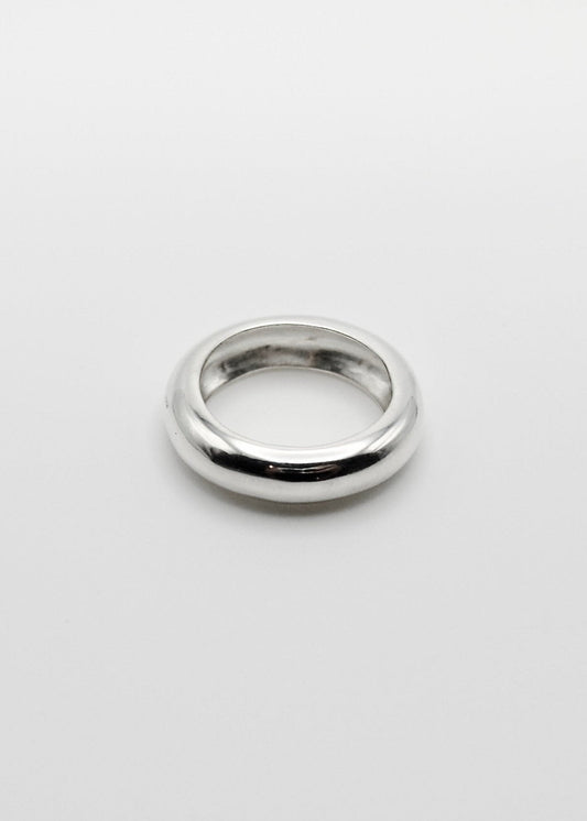 Jooni Ring displayed on a neutral background, highlighting its organic, round-shaped design and mirror-polished sterling silver finish.