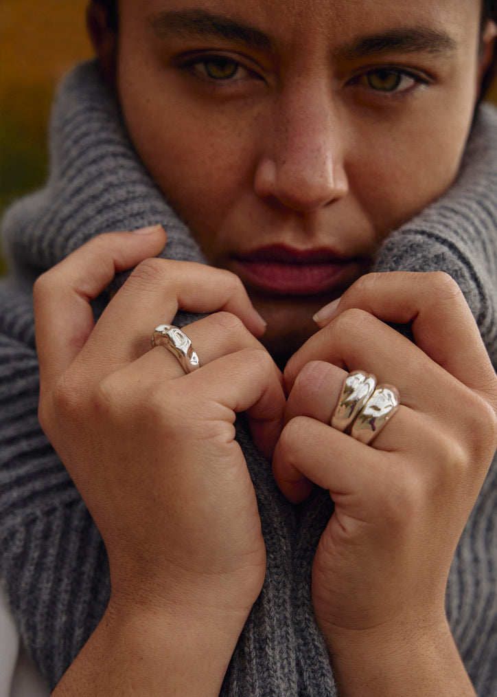 Close-up of a model's hand wearing the Esther Ring together with the floar and willow ring, emphasizing its design and how it complements other stacked rings.