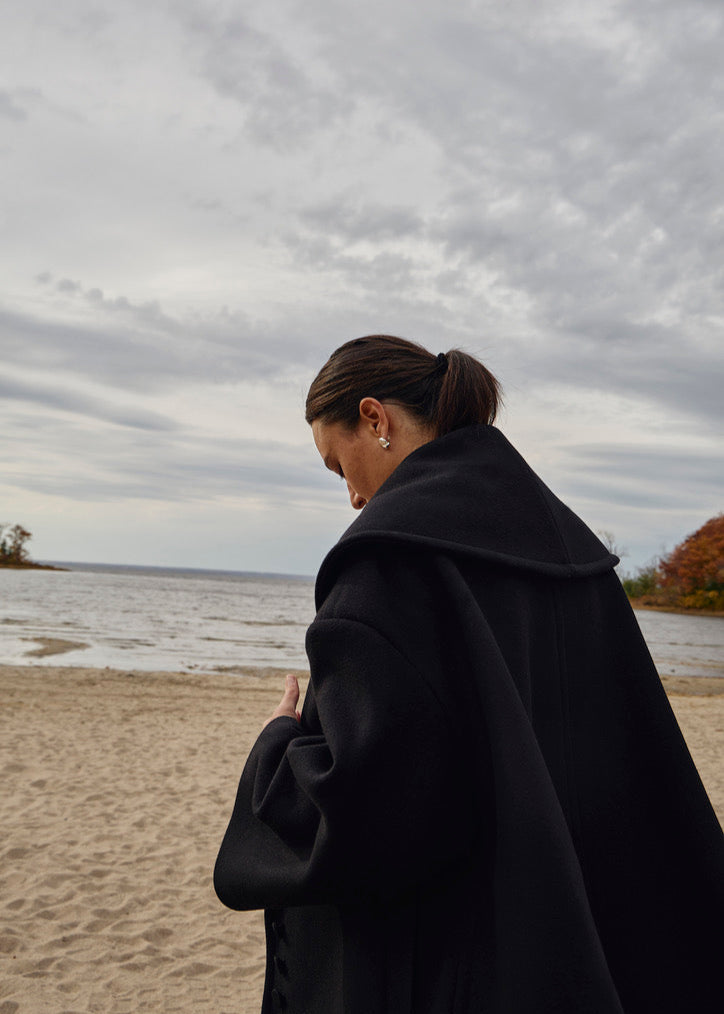 Minimalist silver jewelry, The Gaia Earrings worn by a model, highlighting their sleek, reflective design and how they complement modern, everyday outfits with a touch of sophistication.