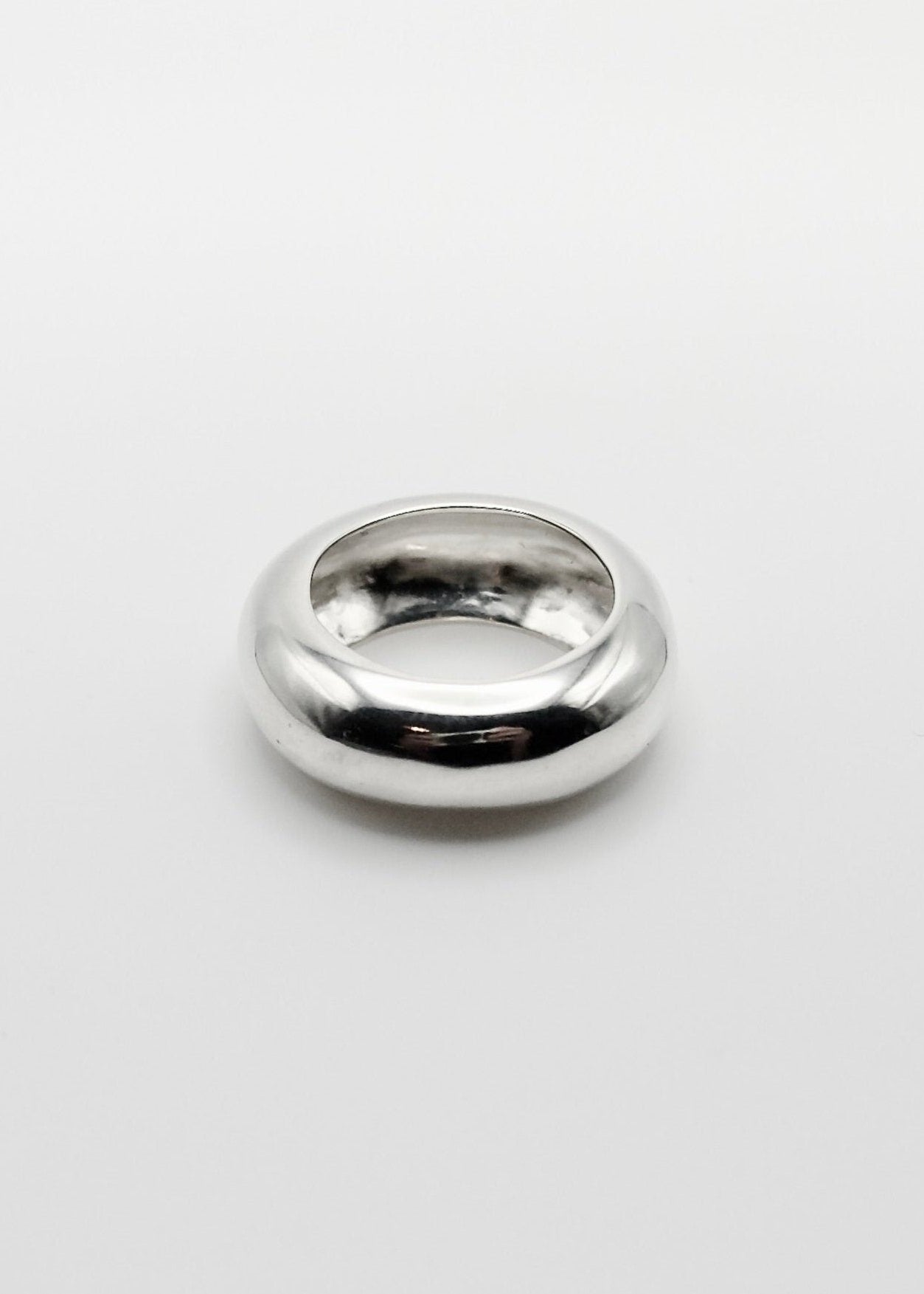 Nilou Ring displayed on a neutral background, highlighting its organic, statement round-shaped design and mirror-polished sterling silver finish.
