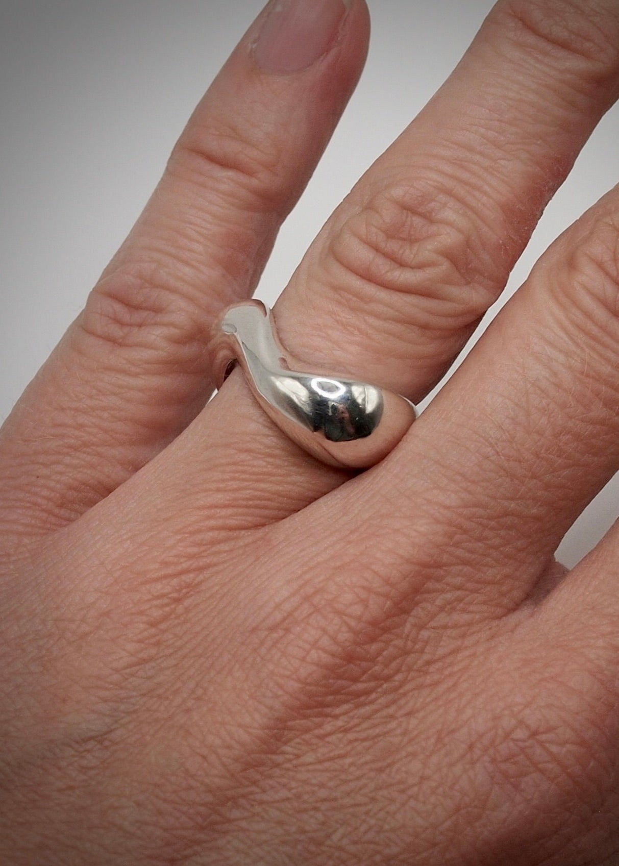 Detailed view of the Clara Ring on hand, focusing on its intricate craftsmanship and the reflective quality of the 925 sterling silver.