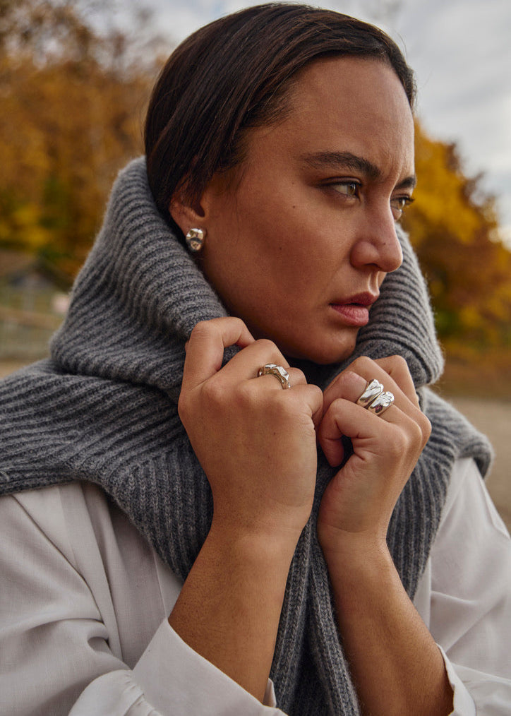 The Gaia Earrings worn by a model, highlighting their sleek, reflective design and how they complement modern, everyday outfits with a touch of sophistication.