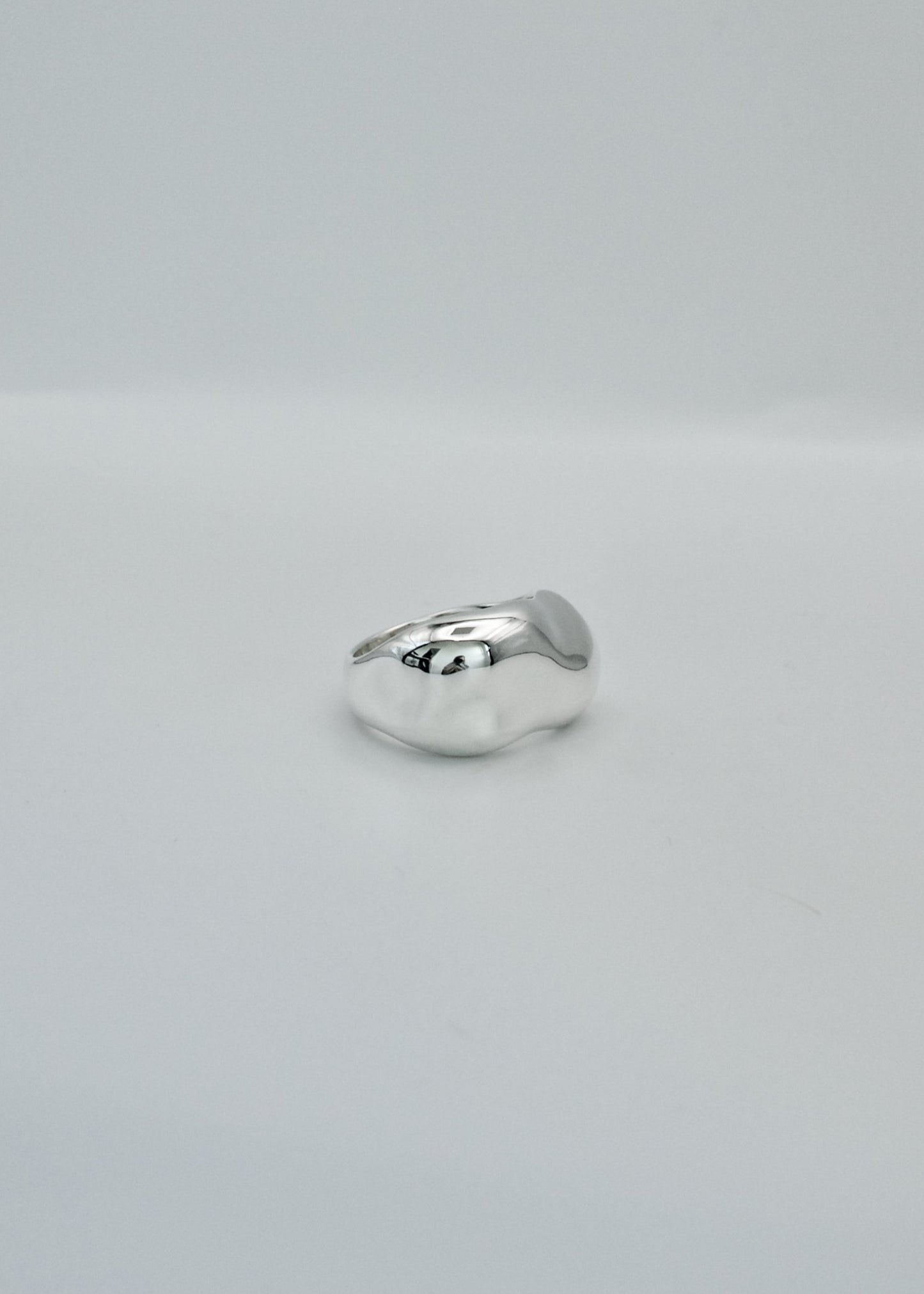 Silver ring on a light gray background