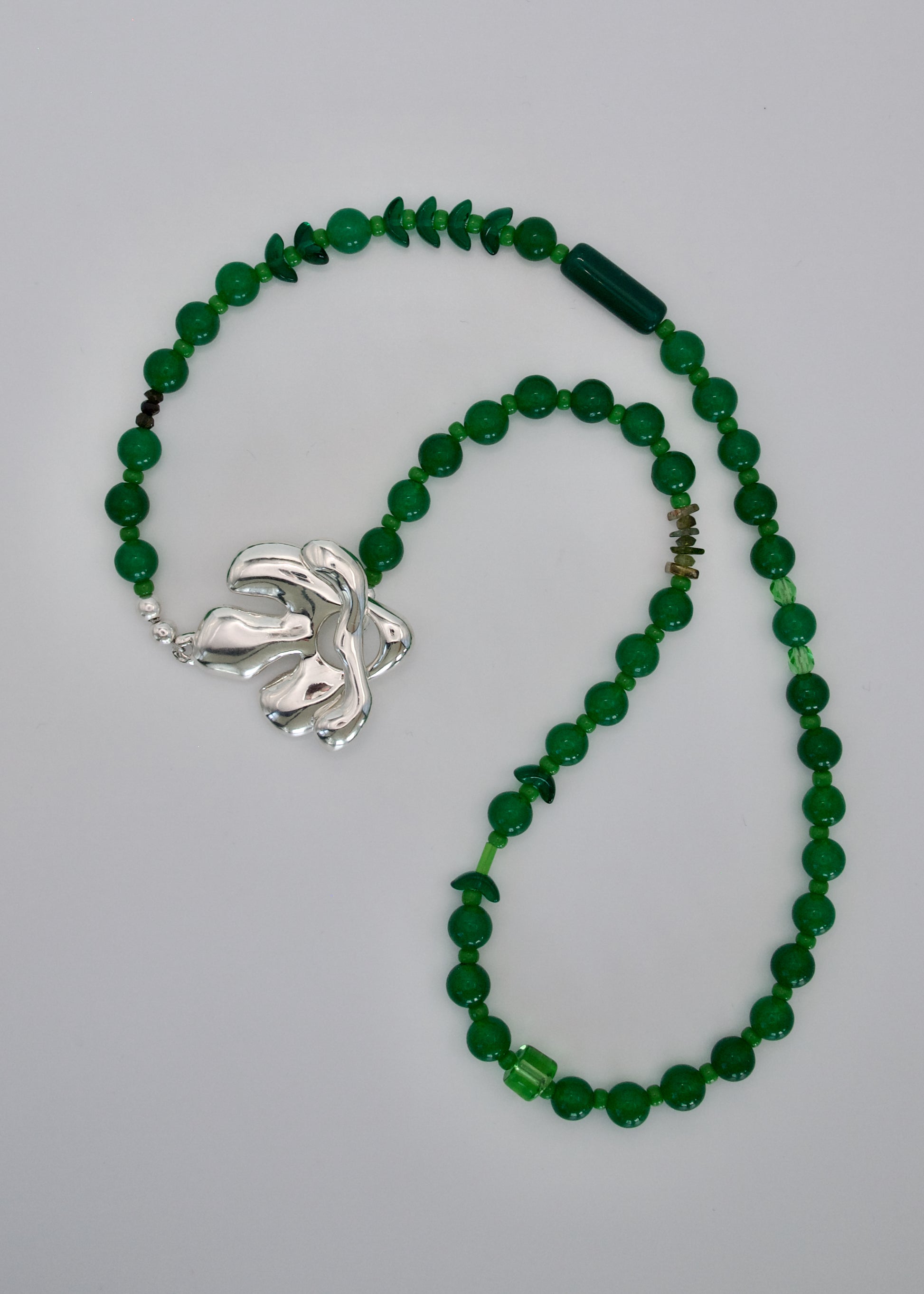 Green beaded necklace with a silver clasp on a gray background