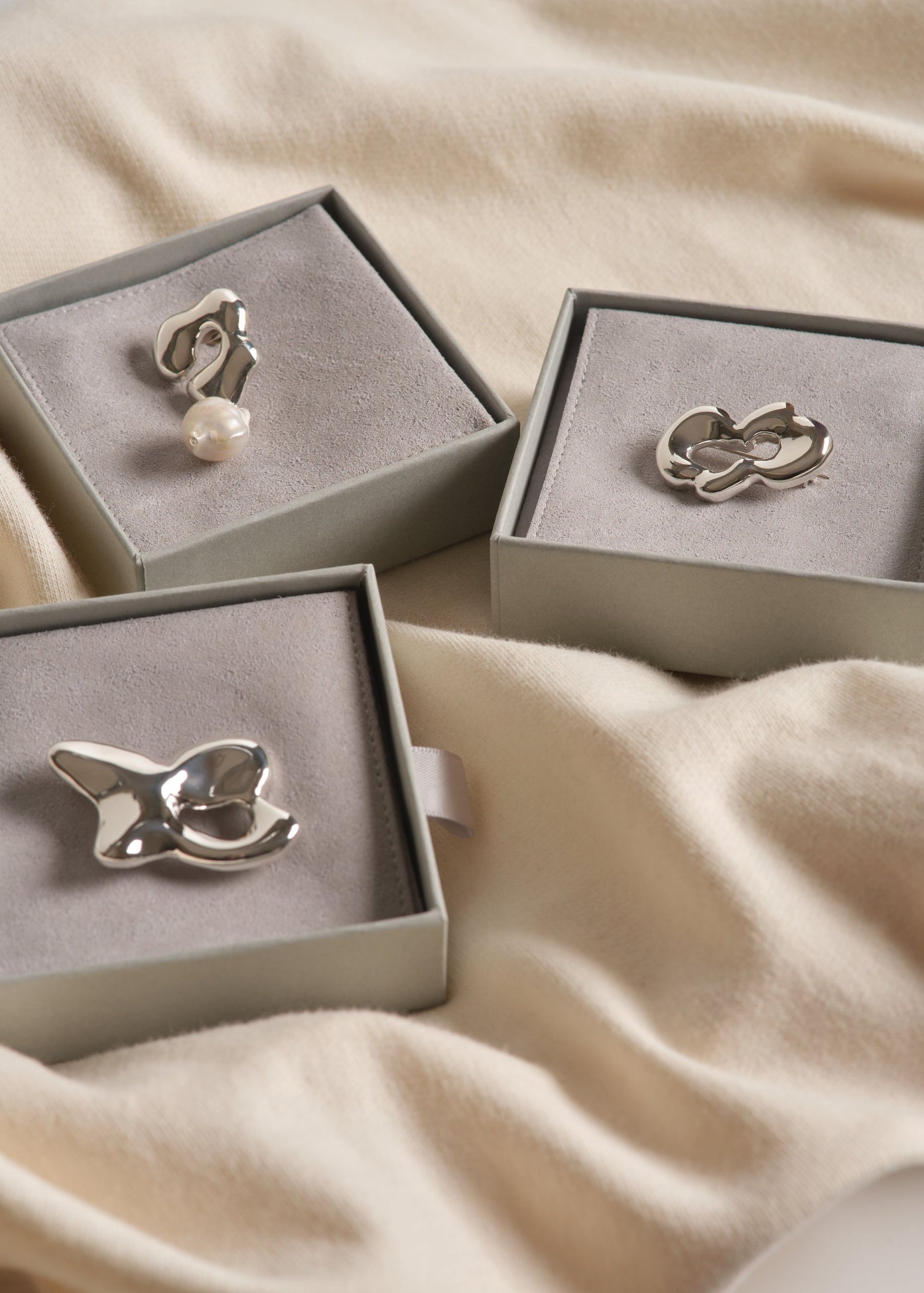 contemporary handmade silver brooches with abstract shapes styled on outerwear, scarf or sweater from seola atelier
Ensemble de trois broches sculpturales en argent sterling aux formes organiques – SÉOLA Atelier