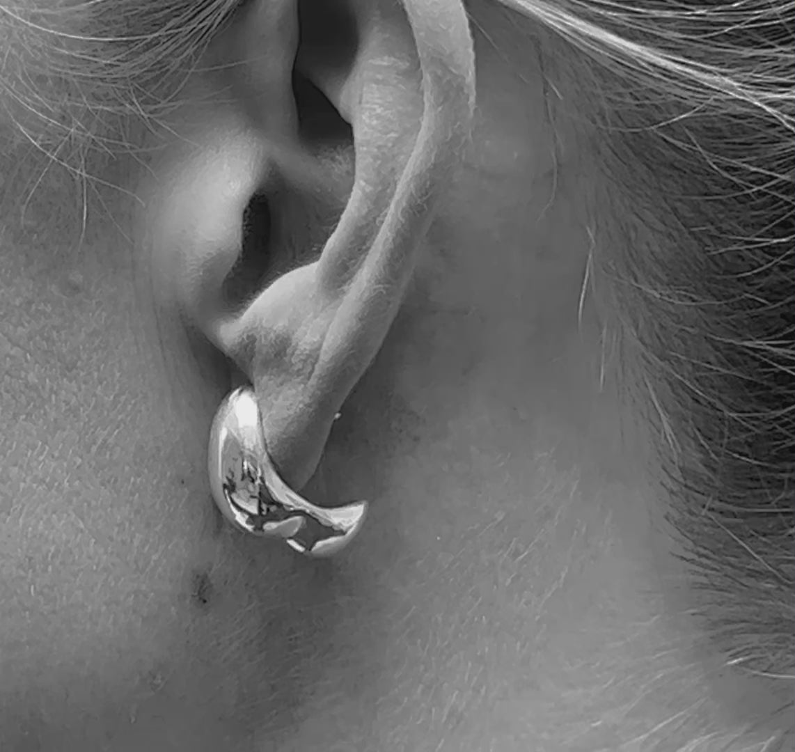 Detailed view  on model of the Sigrid Earrings, focusing on the intricate craftsmanship and reflective surface of the 925 sterling silver.