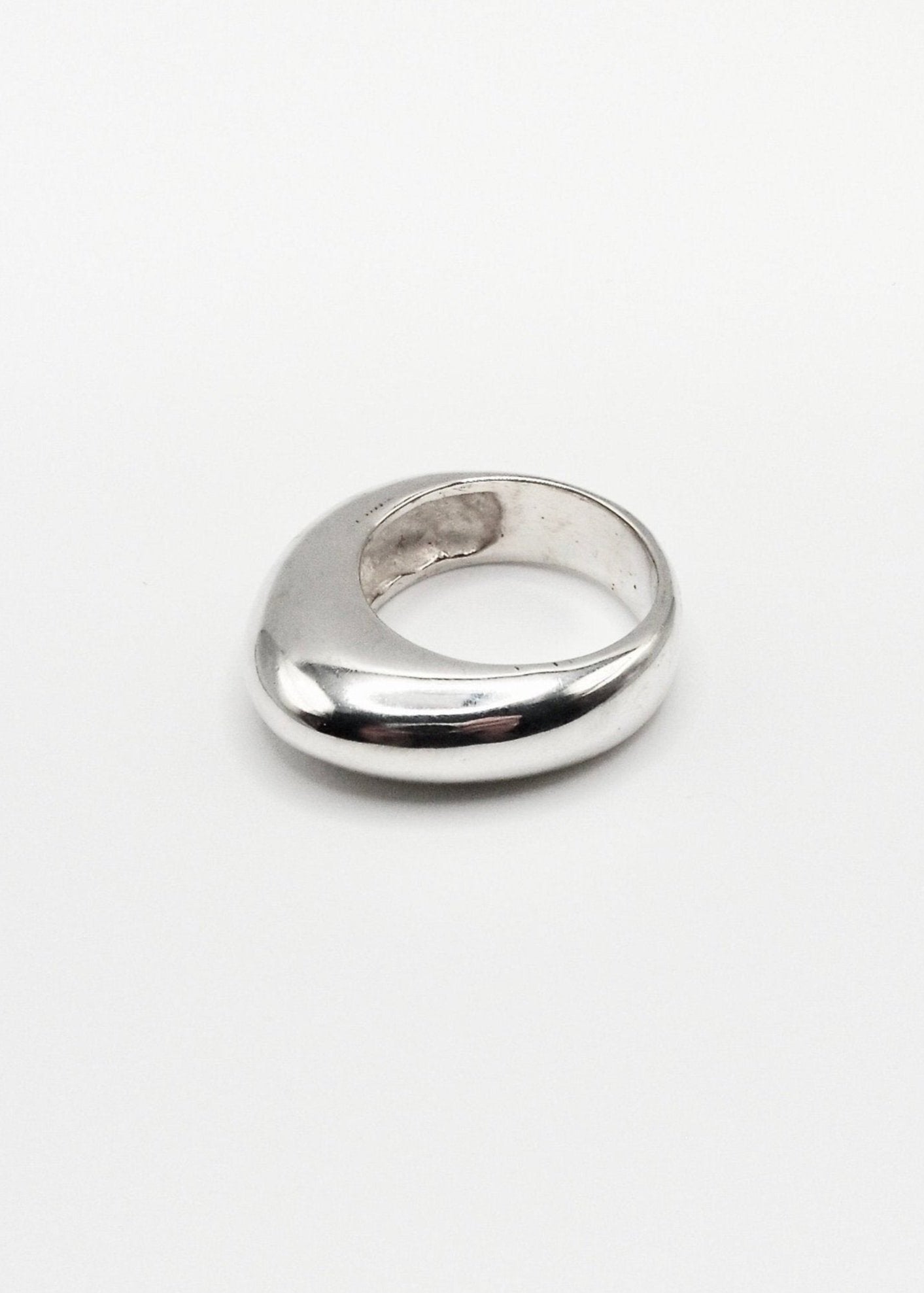 Astrid Ring displayed on a neutral background, highlighting its sleek design and mirror-polished sterling silver finish.
