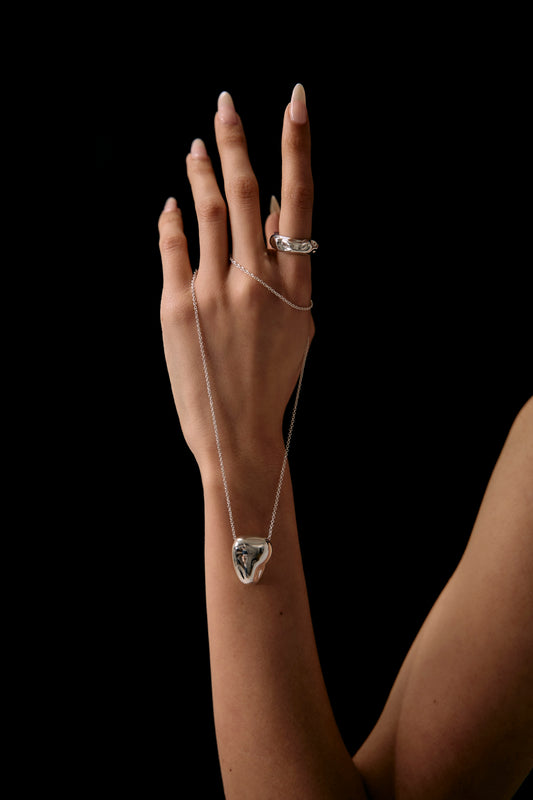 Heart pendant, hold by the models hand, a sculptured handmade piece from Seola Atelier 