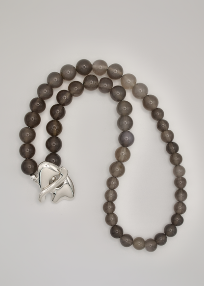 Beaded necklace with a silver clasp on a light gray background